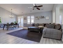 Bright, open living space with modern decor, ceiling fan, and dining area at 6722 S Winnipeg Cir # 102, Aurora, CO 80016