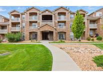 A beautiful condo with stone accents, multiple balconies, and a well maintained green space creates curb appeal at 7440 S Blackhawk St # 2-203, Englewood, CO 80112
