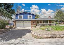 Charming two-story home boasts a blue exterior, brick accents, and a convenient two-car garage at 12821 W 60Th Ave, Arvada, CO 80004