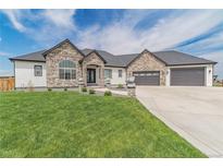 Charming home featuring stone accents, a well-manicured lawn, and a spacious driveway at 29585 E 165Th Ave, Brighton, CO 80603