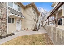 A charming tan two-story home boasts a stone accent wall and a well-maintained front yard with mature trees at 2285 Coronado Pkwy # D, Denver, CO 80229