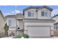 Two-story house with a light beige exterior, attached garage, and landscaping at 20112 E Grand Pl, Aurora, CO 80015