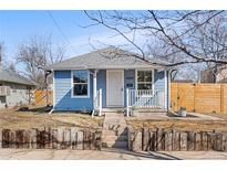 Charming blue home with a white picket fence and a cozy front porch on a sunny day at 4846 Knox Ct, Denver, CO 80221