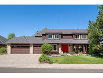 Charming two-story home with a red front door, a three-car garage, and a well-maintained lawn at 5753 S Kittredge St, Centennial, CO 80015