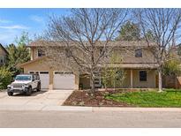 Charming two-story home featuring a well-manicured front yard, two-car garage, and beautiful mature trees at 6219 S Krameria St, Centennial, CO 80111