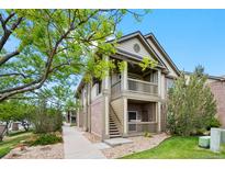 Inviting two-story condo featuring brick accents, dual balconies, and landscaped grounds at 23451 E 5Th Dr # 203, Aurora, CO 80018
