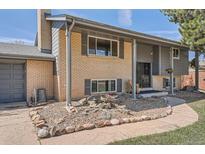 Charming two-story home features a well-maintained lawn and traditional brick facade at 13086 E Alaska Ave, Aurora, CO 80012