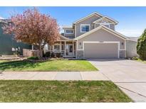 Charming home with a two car garage, neutral paint, and lush landscaping at 19064 E Oak Creek Way, Parker, CO 80134