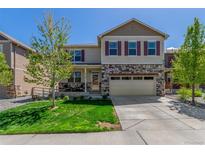 Charming two-story home featuring stone accents, a well-manicured lawn, and a convenient two-car garage at 5758 Echo Park Cir, Castle Rock, CO 80104