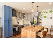 Modern kitchen with stainless steel appliances and butcher block island at 4570 E Yale Ave # 306, Denver, CO 80222