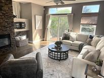 Comfortable living room features a stone fireplace, abundant natural light, and stylish decor at 8922 S Tuscany Ln, Highlands Ranch, CO 80130