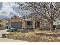 Charming two-story home featuring a stone and siding facade, covered porch, and well-maintained front yard at 333 Mesa St, Brighton, CO 80601