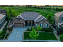 Beautiful home with stone and siding details, a well-manicured lawn, and an attached two-car garage in a golf community at 27615 E Moraine Dr, Aurora, CO 80016