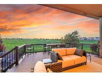 Spacious patio overlooking a green golf course with comfortable seating and a beautiful sunset view at 27615 E Moraine Dr, Aurora, CO 80016