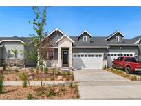 Charming home featuring white brick and gray siding with a two-car garage and manicured rock landscaping at 23936 E River Front Dr, Aurora, CO 80019