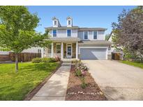 Charming two-story home with stone accents, a well-manicured lawn, and a welcoming front porch at 15649 E 7Th Cir, Aurora, CO 80011