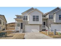 Charming modern farmhouse featuring stone accents, bright white siding, and a two-car garage at 1785 Grayside Cir, Castle Rock, CO 80109