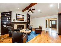 Warm and inviting living room with fireplace, hardwood floors, and comfortable seating arrangement for cozy gatherings at 10601 E Crestline Ave, Englewood, CO 80111