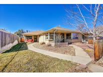 Charming single-story home with manicured lawn, walkway, and mature landscaping at 3209 N Olive St, Denver, CO 80207