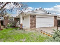 Charming single-story home featuring a brick and white painted exterior and an attached two-car garage at 18830 E 16Th Pl, Aurora, CO 80011