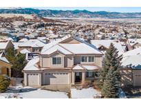 Two-story house with snow covered roof, in a neighborhood with mountain views at 1275 Exquisite St, Castle Rock, CO 80109
