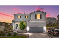 Charming two-story home with a gray exterior, well-manicured lawn, and attached two-car garage at 42853 Ivydel St, Elizabeth, CO 80107