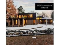 Striking modern home featuring a balcony, brick accents, and large windows, offering a blend of architectural style and cozy living at 7177 W 8Th Ave, Lakewood, CO 80214