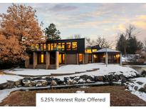 A modern two-story home with large windows and a well-kept landscape covered with snow at 7177 W 8Th Ave, Lakewood, CO 80214