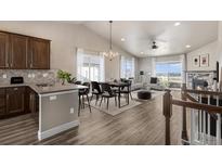 Open-concept living area featuring a stone fireplace, modern furnishings, and abundant natural light at 2371 Pelican Bay Dr, Monument, CO 80132