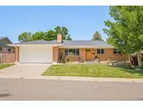 Charming single-story brick home with a well-manicured lawn and an attached two-car garage at 3025 S Norman Ct, Denver, CO 80224