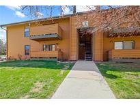 Inviting exterior of a two-story condo featuring a balcony, wood siding, and well-maintained lawn at 3345 S Ammons St # 5-102, Lakewood, CO 80227