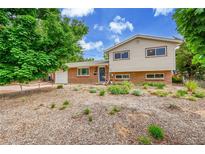 Charming brick and siding home with a blue front door and neatly landscaped yard at 962 S Potomac Way, Aurora, CO 80012