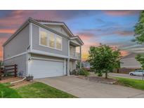 Charming two-story home with a two-car garage, complemented by a well-maintained lawn and mature tree at 249 Vista Blvd, Brighton, CO 80603