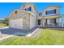 Charming two-story home with gray siding, brick accents, well-manicured lawn and a welcoming front porch at 5912 Randolph Ave, Castle Rock, CO 80104