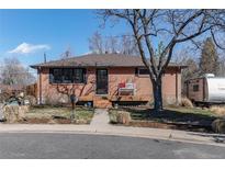 Charming brick home featuring a cozy front porch and a well-manicured front yard at 6361 S Spotswood Cir, Littleton, CO 80120