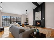 Inviting living room featuring a fireplace, vaulted ceilings, and a large window at 12592 E Bates Cir, Aurora, CO 80014