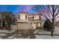 Charming two-story home featuring stone accents, red shutters, well-kept lawn and two-car garage at 5562 Gibraltar St, Denver, CO 80249