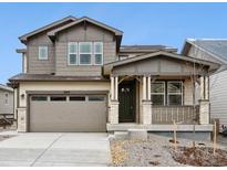 Charming two-story home with a well-manicured lawn, inviting front porch, and attached two-car garage at 8145 Cokedale Cir, Littleton, CO 80125