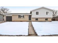 Charming split-level home featuring a brick facade and attached garage, perfect for suburban living at 5153 Tucson Way, Denver, CO 80239