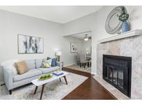 Inviting living room with a fireplace and an open view to the dining area for seamless entertaining at 8260 Washington St # 78, Denver, CO 80229