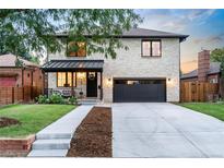 Beautiful two-story stone house with a well-manicured lawn and a dark gray garage door at 1157 Jersey St, Denver, CO 80220