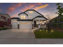 Charming two-story white home with a three-car garage and a welcoming front porch at sunset at Reunion Freunion F Mobile St, Commerce City, CO 80022