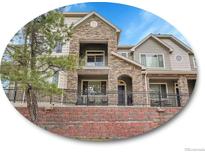 Beautiful multi-level home with stone accents, balconies, and well-maintained landscaping at 9085 E Phillips Dr, Centennial, CO 80112