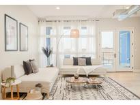 Bright living room features stylish sectional sofa and large windows at 3198 Blake St # 402, Denver, CO 80205