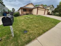 Charming home featuring well-maintained lawn, inviting front porch, and appealing exterior paint scheme at 2239 S Truckee St, Aurora, CO 80013