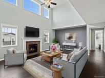 Bright living room featuring high ceilings, fireplace, and ample natural light through large windows at 10730 Hillrose St, Parker, CO 80134