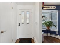 Inviting entryway with white door and wood flooring at 9044 W 63Rd Ave, Arvada, CO 80004