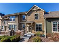 Charming two-story townhouse featuring a stone porch, wood siding, and manicured landscaping at 535 Lost Valley Pt, Castle Rock, CO 80108