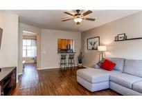 Inviting living room boasts wood floors, ceiling fan, and comfortable seating area with grey sectional at 535 Lost Valley Pt, Castle Rock, CO 80108