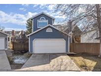 Charming home featuring a two-car garage, blue siding, and a neatly maintained front yard at 717 Walden Ct, Highlands Ranch, CO 80126